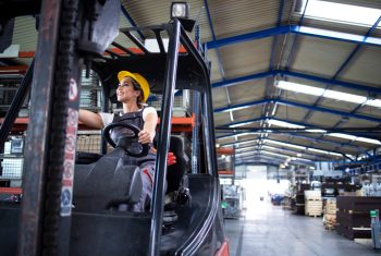 female-industrial-driver-operating-forklift-machine-in-factory-s-warehouse